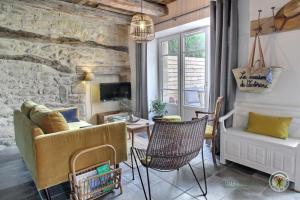 ein Wohnzimmer mit einem Sofa und einem Tisch in der Unterkunft La maison de victorine in Dinan