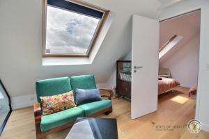 ein Wohnzimmer mit einem grünen Stuhl und einem Fenster in der Unterkunft La ritournelle in Pleslin-Trigavou