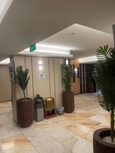 a lobby with three potted plants in a building at شقق كيان البستان للشقق المخدومة in Al Ahsa