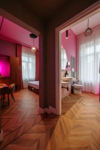 a bathroom with pink walls and a sink and a toilet at Momento Soggiorno di Charme in Foggia