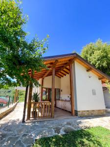 a home with a porch with a wooden roof at Villa Ksilifor in Veliko Tŭrnovo