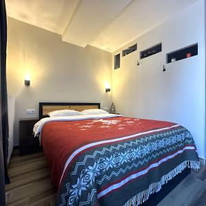 a bedroom with a large bed with a red blanket at New Gudauri Loft 2 - Mountain Harmony, Quiet & Cosy Place Next to Main Lift in Gudauri