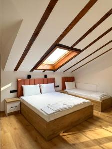 two beds in a attic bedroom with a skylight at Villa Ksilifor in Veliko Tŭrnovo
