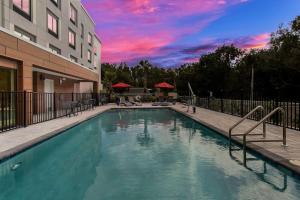 una piscina frente a un edificio con puesta de sol en Hampton Inn & Suites Ruskin I-75, FL, en Ruskin