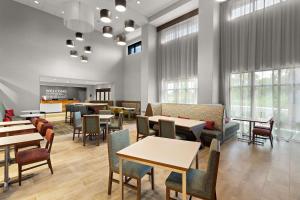 un comedor con mesas, sillas y ventanas en Hampton Inn & Suites Ruskin I-75, FL, en Ruskin