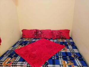 - un lit avec des draps rouges et des oreillers rouges dans l'établissement Wander Valley, à Ooty