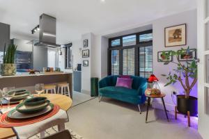 a living room with a blue chair and a table at Modern Double bedroom in city apartment room 2 in London