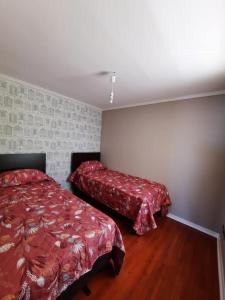 a bedroom with two beds with red sheets in it at Depto equipado frente al mar. Hemosa vista in Concón