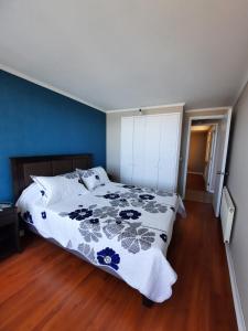 a bedroom with a bed with a blue wall at Depto equipado frente al mar. Hemosa vista in Concón