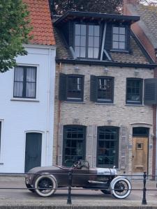 um carro velho estacionado em frente a uma casa em Toplocatie in centrum Sluis em Sluis