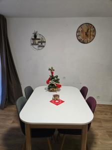 une table blanche avec un arbre de Noël en haut dans l'établissement Studio Le Tétras Résidence de tourisme, à La Féclaz