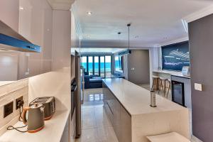 uma cozinha com uma ilha e uma chaleira. em Chakas Terrace 7 - Luxurious Beach House em Ballito