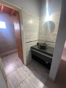 a bathroom with a sink and a mirror at Casa Vip Pileta Climatizada Carlos Paz in Tanti