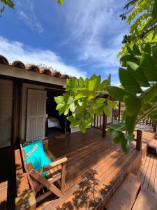 una terraza de madera con una silla en una casa en Pousada Piraúna en Fernando de Noronha