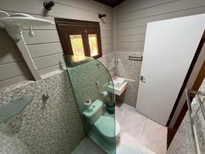 uma casa de banho com um chuveiro e um lavatório. em Pousada Piraúna em Fernando de Noronha