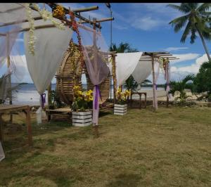 a row of tents on the beach with flowers at Palaboy Skatecamp Beach Resort 
