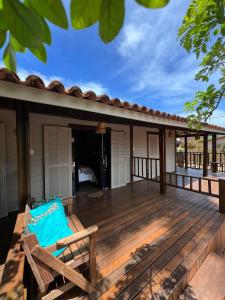 een houten terras met een stoel op een huis bij Pousada Piraúna in Fernando de Noronha