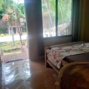 a bedroom with a bed and a large window at Palaboy Skatecamp Beach Resort 