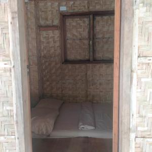 a small room with a bed in a brick wall at Palaboy Skatecamp Beach Resort 