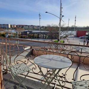 a table and chairs on a balcony with a street at Charming appartement with a view of the Saone in Mâcon