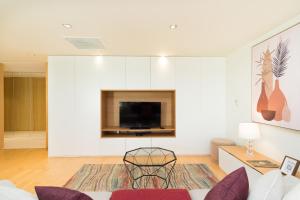 uma sala de estar com um sofá e uma televisão em Scala Cascais Top apartment em Cascais