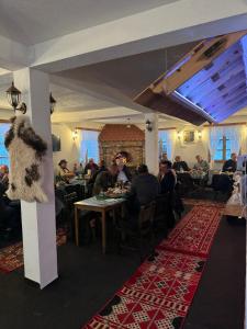 a group of people sitting at tables in a restaurant at Bjelasnica-Villa-Treskina dvorišta-Apartmani-Izletište-Ribnjak in Sarajevo