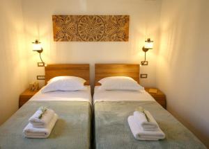 PilaroúにあるUnity Villaのベッドルームにタオル付きのベッド2台が備わります。