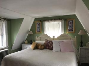 Un dormitorio con una cama blanca con almohadas. en The Monadnock Inn, en Jaffrey