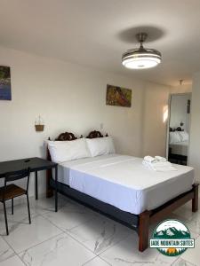 a bedroom with a large bed and a table at Jade Mountain Suites, Jarabacoa in Jarabacoa