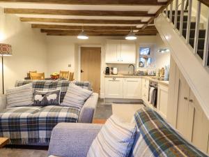 a living room with two couches and a kitchen at Bwthyn Y Bugail in Blaenau-Ffestiniog +8 photos