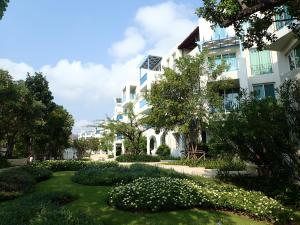 a building with a garden in front of it at Chelona Hua Hin in Khao Tao