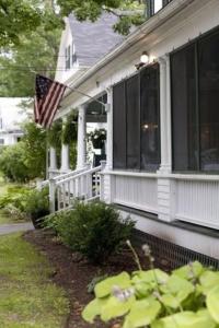 una casa con una bandera americana en el porche delantero en The Monadnock Inn en Jaffrey