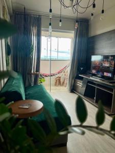 a living room with a green couch and a television at Apartamento decorado no Jardim Lancaster in Foz do Iguaçu