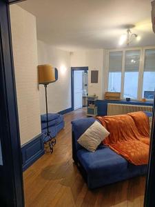 a bedroom with a bed and a couch with a pillow at Appartement au charme authentique in Mirecourt