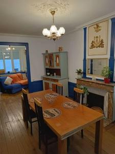 a dining room with a table and a fireplace at Appartement au charme authentique in Mirecourt