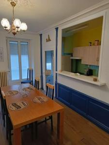 a kitchen and dining room with a table and chairs at Appartement au charme authentique in Mirecourt