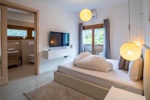 a bedroom with a bed with a television and a bathroom at Stay with Gamauf in Fonyód