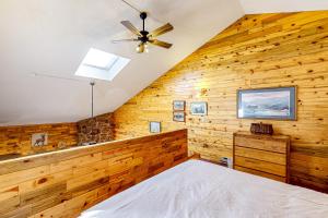 1 dormitorio con paredes de madera y ventilador de techo en Inn at Silver Creek #630, en Granby