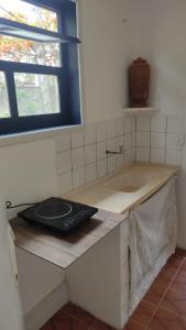 a kitchen with a counter with a sink and a window at Casinha do Peró in Cabo Frio