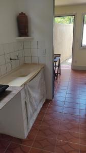 a kitchen with a counter top and a tile floor at Casinha do Peró in Cabo Frio
