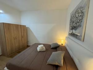 1 dormitorio con 1 cama grande de madera y 2 almohadas en Civico 19 2PAX, en Sassari