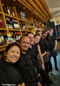 a group of people posing for a picture in a bar at The Wellsprings Lodges and Restaurant in Clitheroe