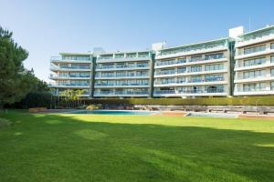 a large apartment building with a green lawn in front of it at Scala Cascais Top apartment in Cascais