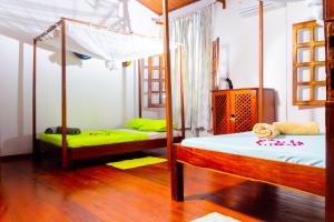 een slaapkamer met 2 stapelbedden met groene lakens bij Appartement vue sur mer chez VILLA AMNESYA in Nosy Be