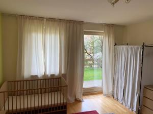Habitación con ventana grande con cortinas blancas. en Haus Amalia, en Kramsach