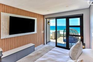 a bedroom with a flat screen tv on a wall at Chakas Terrace 7 - Luxurious Beach House in Ballito
