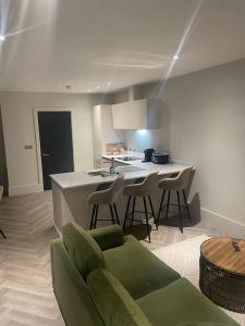 a kitchen with a couch and chairs in a room at Luxurious 1 Bed - CITY VIEWS in Liverpool
