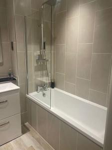 a bathroom with a shower with a tub and a sink at Luxurious 1 Bed - CITY VIEWS in Liverpool