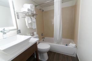 a bathroom with a sink and a toilet and a tub at Marjac Suites Virginia Beach Oceanfront in Virginia Beach +14 photos