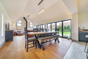 a dining room with a table and a couch at EASTFIELD HOUSE in Whissonsett